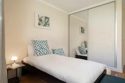 a bedroom with a large white bed and a window at Calheta Victory View by An Island Apart in Calheta