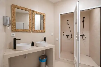a bathroom with two sinks and a shower at The Lighthouse Hostel in Sagres