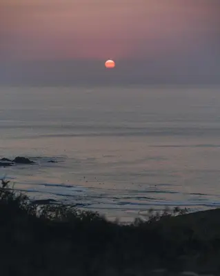 a sunset over the ocean with the sun in the sky at The Lighthouse Hostel in Sagres