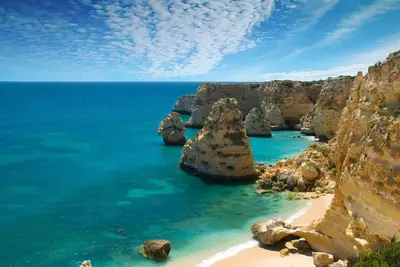 a bedroom with two beds with white sheets and a window at The Lighthouse Hostel in Sagres