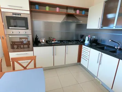 a kitchen with white cabinets and a sink at Agustin's House in Funchal