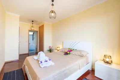 a bedroom with a large bed with towels on it at Gracy Apartment at Garajau in Caniço