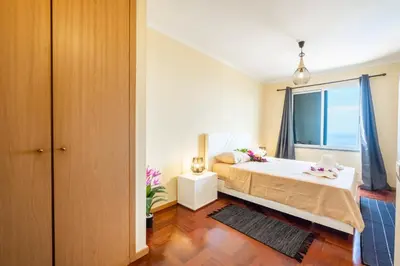 a bedroom with a bed and a window at Gracy Apartment at Garajau in Caniço
