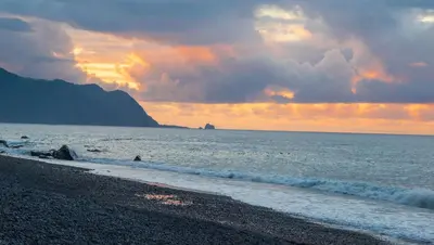 a beach with a cloudy sky and the ocean at Amarelo Apartment by Atlantic Holiday in São Vicente