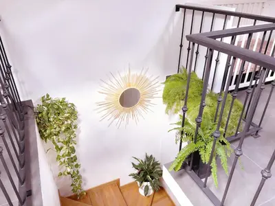 a staircase with plants and a sun on the wall at Angela`s Loft in Ribeira Brava