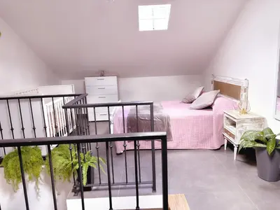 a bedroom with a bed with a pink blanket at Angela`s Loft in Ribeira Brava