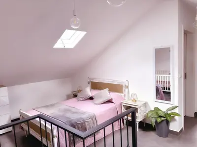 a bedroom with a bed with pink sheets and a window at Angela`s Loft in Ribeira Brava