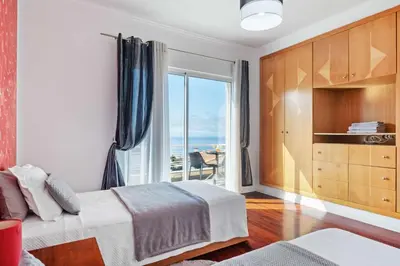 a bedroom with a bed and a large window at Villa Funchal bay view in Funchal