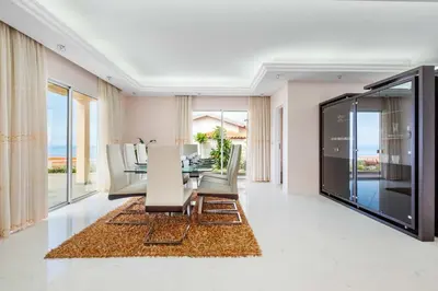 a dining room with a table and chairs and the ocean at Villa Funchal bay view in Funchal