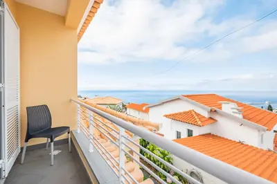 a balcony with a chair and a view of the ocean at Villa Funchal bay view in Funchal