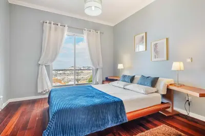 a bedroom with a bed and a large window at Villa Funchal bay view in Funchal