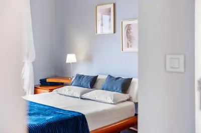 a bed with blue pillows in a room at Villa Funchal bay view in Funchal