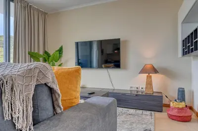 a living room with a couch and a table at Baia Machico, a Home in Madeira in Machico