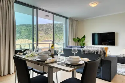 a dining room and living room with a table and chairs at Baia Machico, a Home in Madeira in Machico