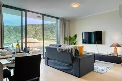 a living room with a couch and a table and a television at Baia Machico, a Home in Madeira in Machico