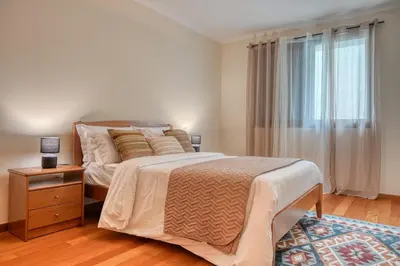 a bedroom with a large bed and a window at Baia Machico, a Home in Madeira in Machico