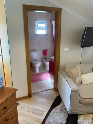 a living room with a couch and a bathroom at Moniz Apartment in Caniço