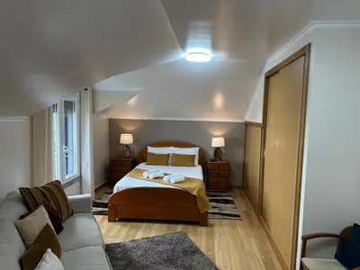 a bedroom with a bed and a couch at Moniz Apartment in Caniço