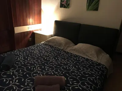 a bedroom with a bed with a black and white comforter at Apartamentos do Mar Funchal in Funchal