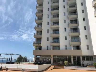 a tall white building with a lot of windows at Apartamentos do Mar Funchal in Funchal
