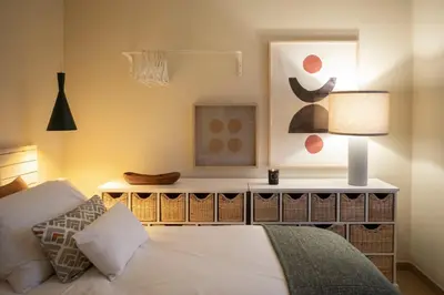 a bedroom with a bed and a table with a lamp at Moonrise Flat in Aljezur