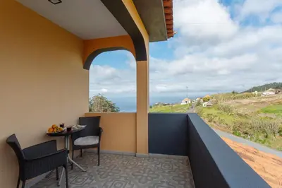 a balcony with a table and chairs and a view of the ocean at Apartamento Maria in Canhas