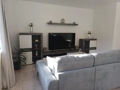 a living room with a couch and a flat screen tv at Apartamento Maria in Canhas