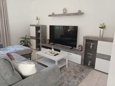 a living room with a couch and a flat screen tv at Apartamento Maria in Canhas
