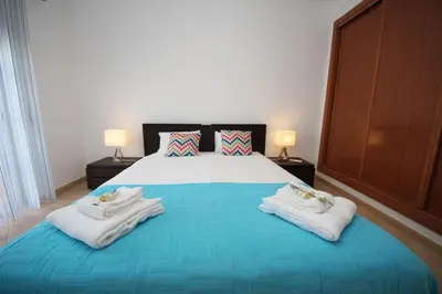 a bedroom with a large bed with towels on it at JM - St James, apart com WIFI, piscina a 50 mt da Praia in Lagos