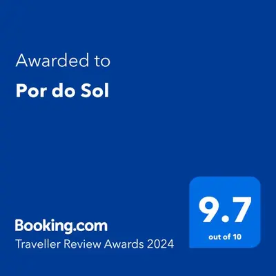 a living room with a table and chairs and a couch at Por do Sol in Caniço