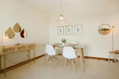 a dining room with a table and white chairs at Sea View Apartment in Funchal