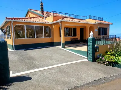 a small yellow house with a large driveway at Casa Vida Alegre in Prazeres