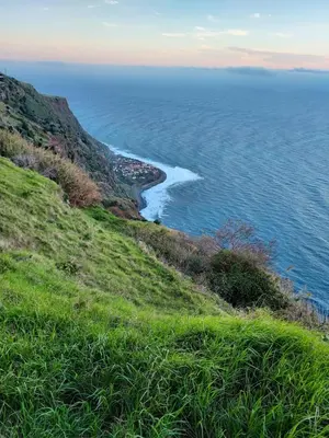 a view of the ocean from a grassy hill at Casa Vida Alegre in Prazeres