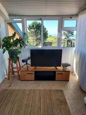 a living room with a large flat screen tv at Casa Vida Alegre in Prazeres