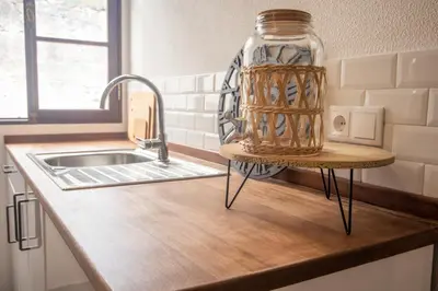 a kitchen counter with a jar on a stand next to a sink at The Village House in Machico