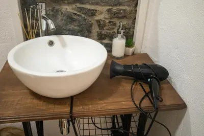 a white bowl sink on a wooden counter in a bathroom at The Village House in Machico