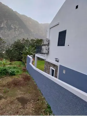 a white building with a fence next to a mountain at CASA GIRASSOL 