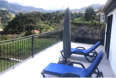 two chairs and an umbrella on a balcony with a view at CASA GIRASSOL 