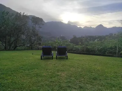 two chairs sitting in a field with mountains in the background at CASA GIRASSOL 
