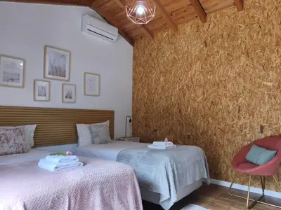 a bedroom with two beds and two chairs at CASA GIRASSOL 