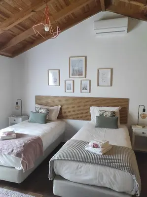 two beds in a room with white walls and wooden ceilings at CASA GIRASSOL 