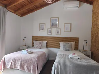 two beds in a room with white walls and wooden ceilings at CASA GIRASSOL 