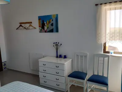 a blue bedroom with a white bed and a blue wall at Vivenda Familia Pedro in Vila do Bispo