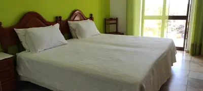 a large white bed in a room with a window at Vivenda Familia Pedro in Vila do Bispo