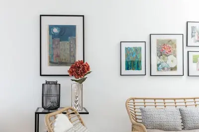 a living room with a vase of flowers and framed pictures at GuestReady - Anakaj House in Funchal