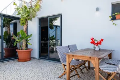 a patio with a wooden table and two chairs at GuestReady - Anakaj House in Funchal