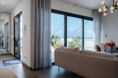 a living room with a couch and a large window at GuestReady - Anakaj House in Funchal