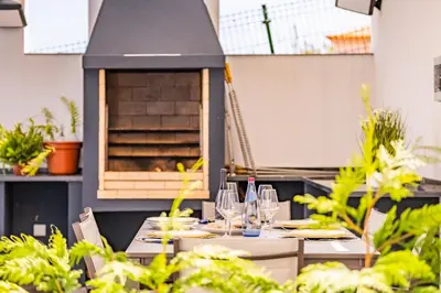 a table with wine glasses and a pizza oven at Belle Maison by Homie in Funchal