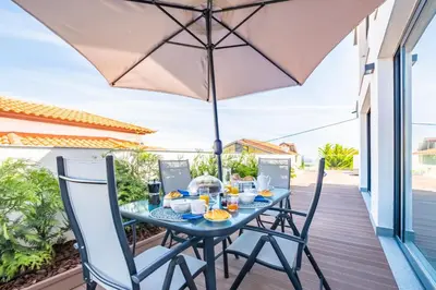 a table with an umbrella on the balcony of a house at Belle Maison by Homie in Funchal