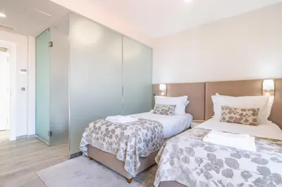 a bedroom with two beds and a mirror at Belle Maison by Homie in Funchal